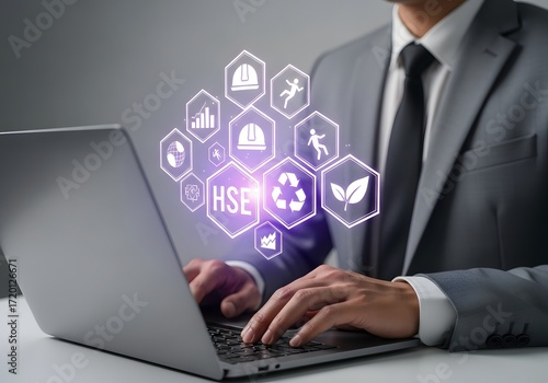 Businessman using laptop with digital hse icons for health safety environment management