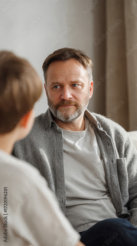 Fototapeta premium Father and son sitting in therapy room during session