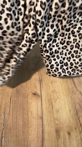 A woman unboxing and reviewing leopard print shorts. Vertical video.