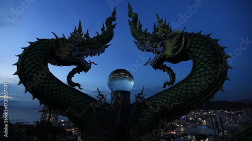 Video background of Chonburi city viewpoint. At the Samnaksong Khao Phra Khru viewpoint in the Sri Racha Thailand,a beautiful Naga statue and a white Buddha statue stand tall among the mountains.