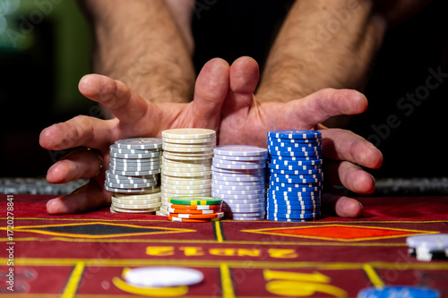 A player playing in a casino raises bets with chips. Gaming business. A player playing in a casino raises the bet with chips. Gaming business.