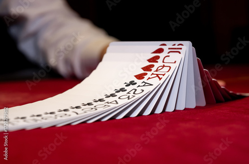 Croupier hands dealing cards on t blackjack poker table, gambling table with cards and chips. The croupier in the casino does a shuffle of cards. Person playing poker.
