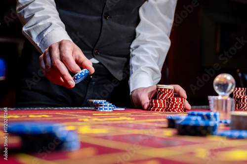 A man places a bet with chips in a casino. A player takes a lot of chips in a casino .Poker game in a casino in Las Vegas. Casino Black Jack table with poker cards