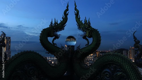Video background of Chonburi city viewpoint. At the Samnaksong Khao Phra Khru viewpoint in the Sri Racha Thailand,a beautiful Naga statue and a white Buddha statue stand tall among the mountains.