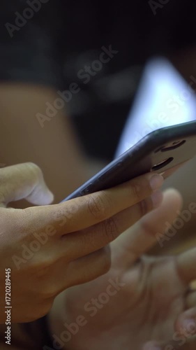 4K Closeup young students are reading a text on phone. Children looking smart phone screen over a wood desk in classroom. Teenager hand holding smartphone to search information. Education concept.