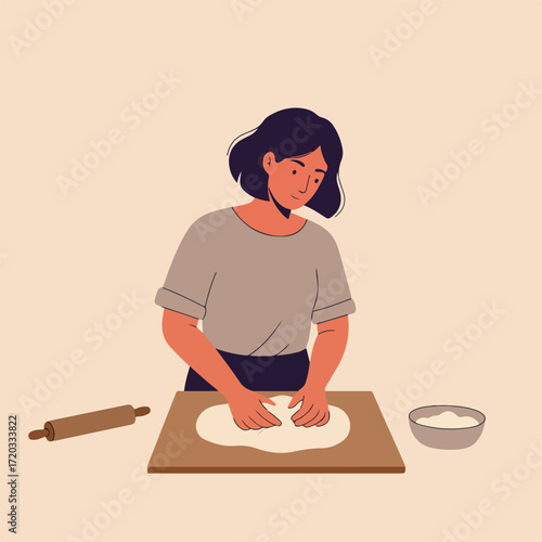 Woman kneads dough on a wooden board, roll and flour bowl nearby