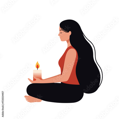 Woman meditating while holding a lit candle