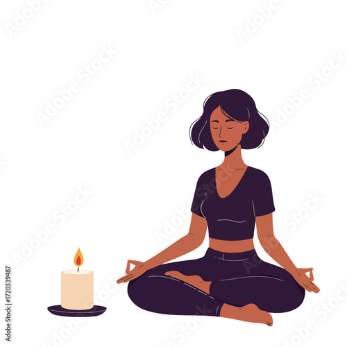 Woman in lotus pose meditating next to a lit candle on white backdrop