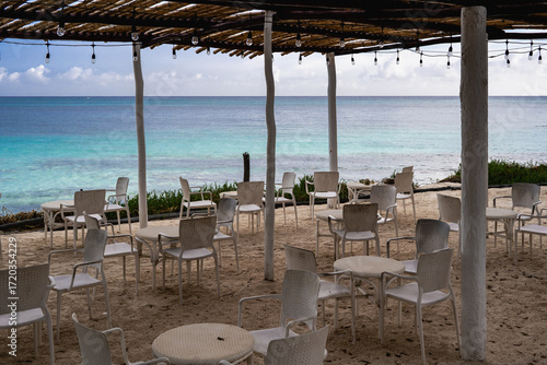 A beachside setting with empty chairs and tables awaiting visitors.