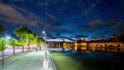 Mandalay palace glows along the moat at night in myanmar