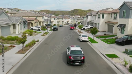 Wallpaper Mural Police car driving down a residential street in a suburban neighborhood Torontodigital.ca