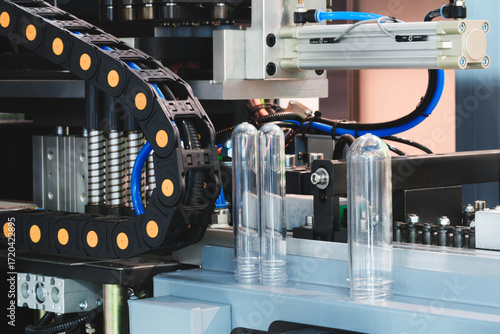 PVC plastic bottle production machine by extrusion and hot blowing technology industrial concept background.