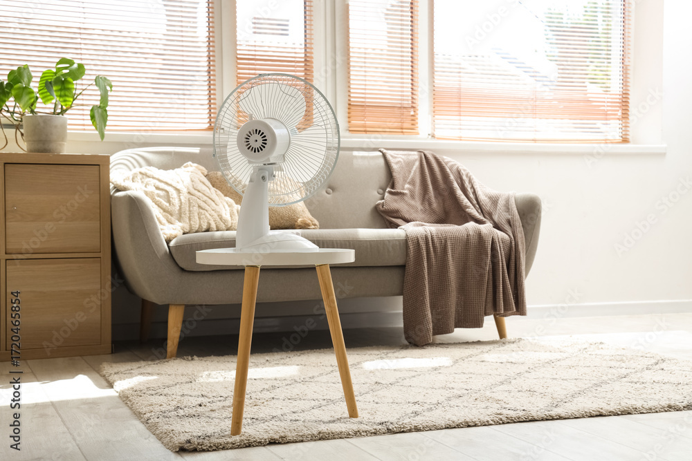 Fototapeta premium Electric fan on table in living room interior