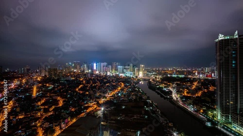 Wallpaper Mural Manila cityscape glows at night with city lights and cloudy skies above Torontodigital.ca
