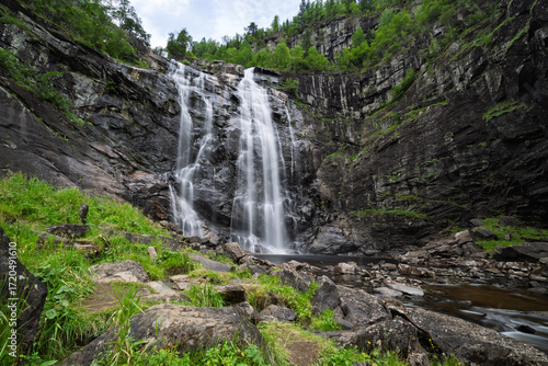 Waterfall cascades down a rocky cliff face.