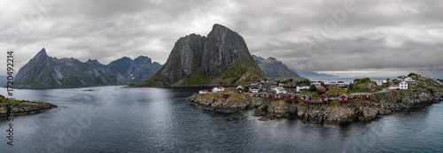 Gloomy fjord landscape with mountains and rocky shore.