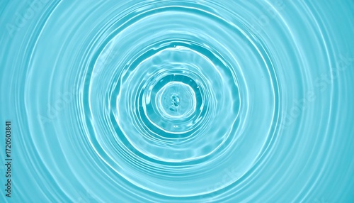 Circular ripples spread outward across a turquoise liquid surface, creating concentric waves with light and shadow play