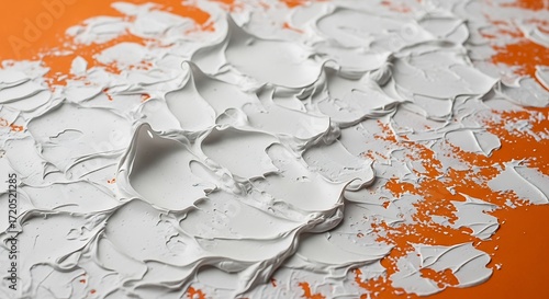 Textured white paint strokes create an abstract design against an orange background.