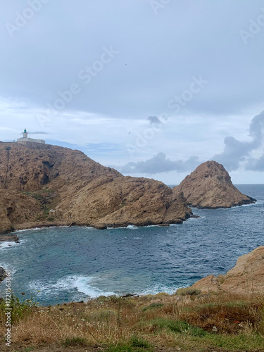 Distant lighthouse atop a cliff overlooking the bay