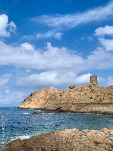 Distant lighthouse on a rock overlooking calm waters