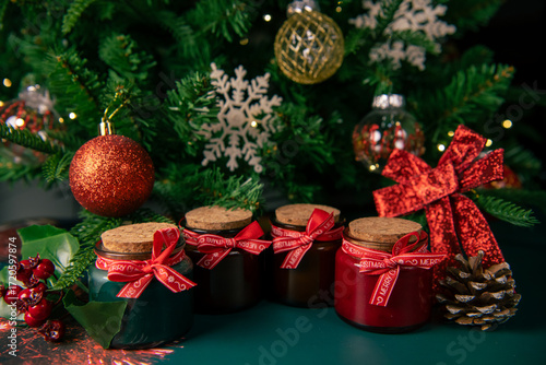 Christmas aroma candles with fir cones on the table with the Christmas tree on a background, copy space