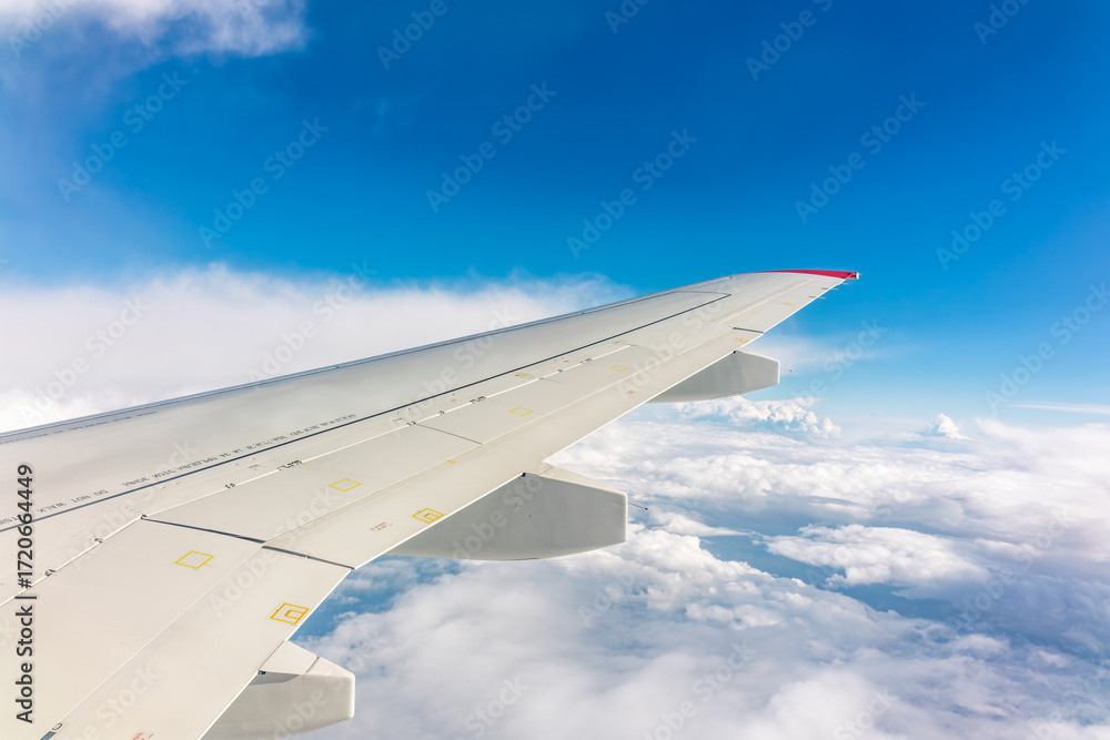 Obraz premium View from the airplane window at a beautiful cloudy sky and the airplane wing
