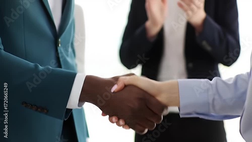 Wallpaper Mural Close up of a handshake between an african american man and a caucasian woman during a business meeting, with colleagues applauding in the background Torontodigital.ca