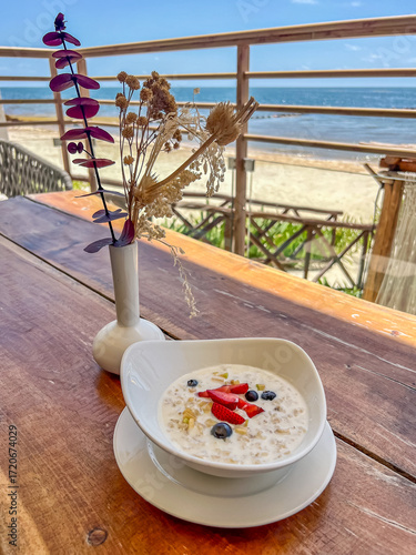 Healthy breakfast for vegetarians. Freshly made oatmeal whith berries. Sunny good morning. Vivacity and energy for the whole day. Vertical photo.