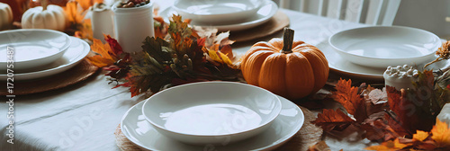 Cozy autumn table setting with pumpkins and fall leaves for thanksgiving dinner