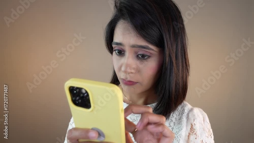 Closeup of bored upset young girl woman client hold cellphone use typing chatting smartphone scrolling online app feels disappointment, isolated over grey background.