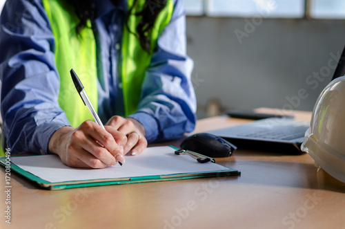 Close up hands of female employee taking notes at industry or warehouse deposit office.