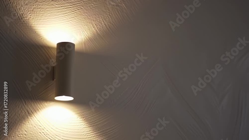 Wall Mounted White Cylinder Light Fixture Emitting Up and Down Lighting