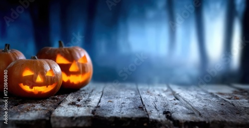 Halloween jack o' lanterns illuminating an old wooden table, standing against a dark, foggy forest background creating a spooky mood