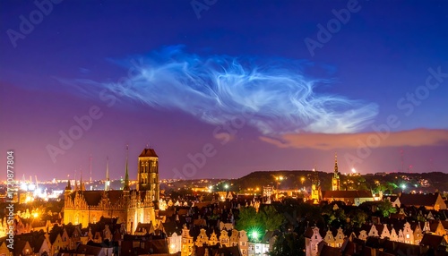 City skyline at twilight, illuminated buildings, unusual clouds
