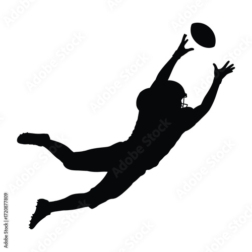 Silhouette of a football player making a diving catch
