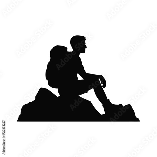 Silhouette of a hiker resting on a rocky outcrop