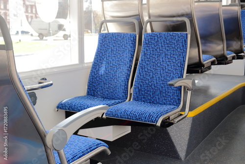 Blue passenger seats on a public tram. An empty tram car with empty seats. Tram seats in an empty car.