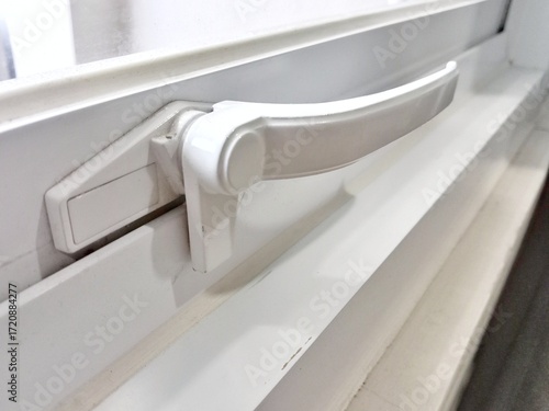 White window handle. White aluminum window lock.