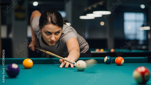 Young woman focuses intently while playing billiards in a cozy bar setting at night
