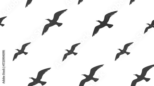 Seamless pattern of stylized dark gray flying bird silhouettes in various orientations