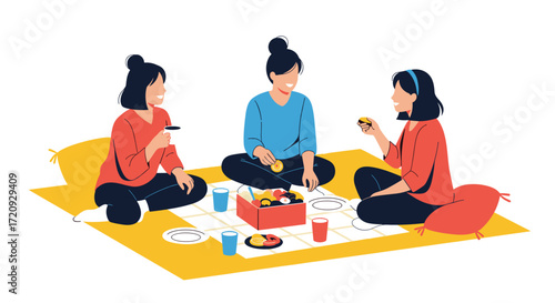 Three young women enjoying a picnic together on a yellow blanket with pillows.
