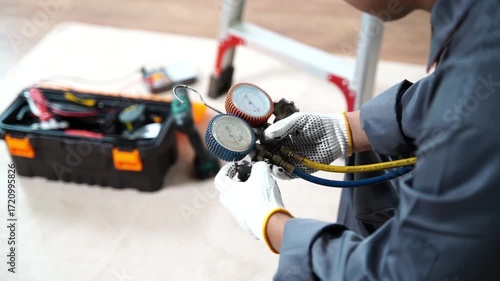 Technician Holding Refrigeration Gauges for HVAC System Maintenance and Performance Checks in a Professional Workshop Setting
