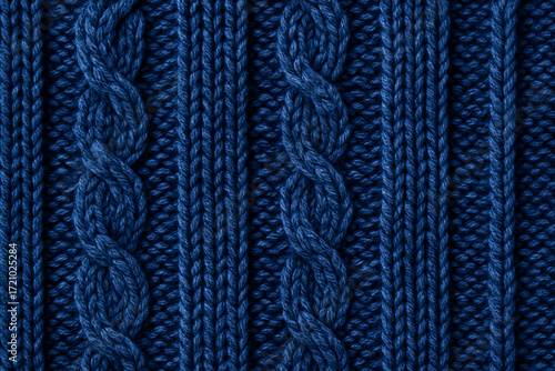 Close-up of blue knitted wool fabric with braided cable pattern. Cozy textured background for winter clothing, fashion design, handmade crafts and interior decoration.