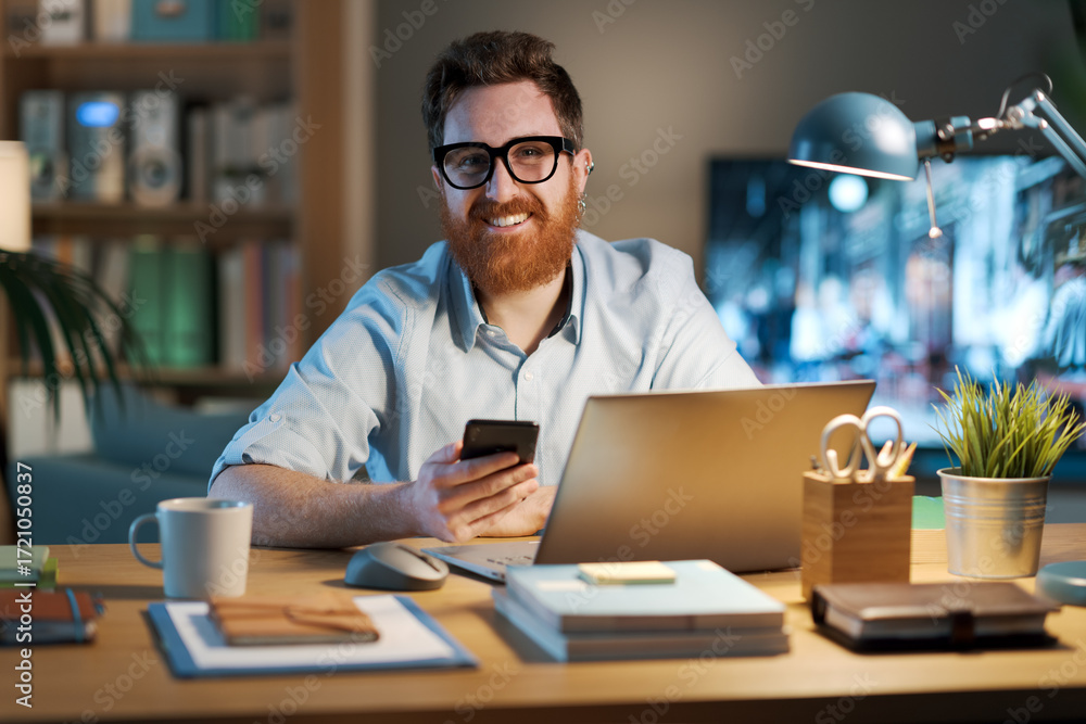Fototapeta premium Businessman working from home and using a smartphone