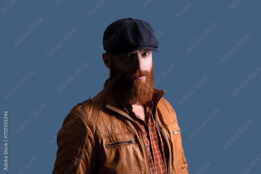Fototapeta premium Brutal man in leather jacket. Man in retro peaky cap. Male formal fashion. Brutal bearded guy. Gangster with beard. Bearded man gangster. Stylish Englishman. Retro man isolated on grey