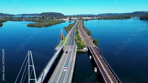 Wallpaper Mural Drone aerial landscape of cars driving along main road highway bridge into Woy Woy town suburbs with train railway line running alongside Central Coast Australia travel transport infrastructure Torontodigital.ca