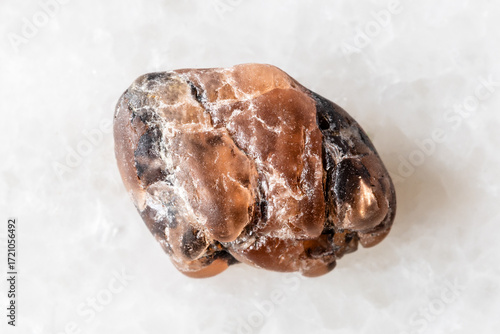 sample of rough triplite mineral on white marble