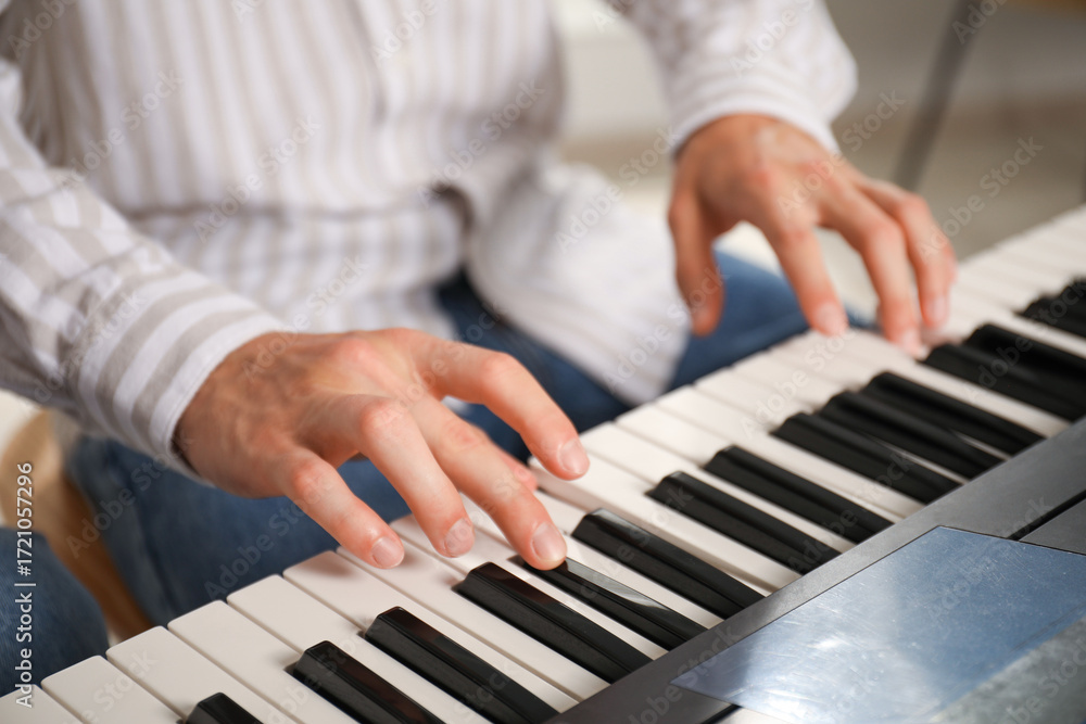 Obraz premium Man learning to play piano indoors, closeup