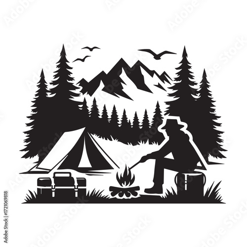 Silhouette of a lone camper tending a campfire with a tent and mountains in the background camping