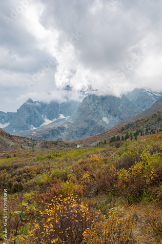 Akchan valley in august with peaks of Altai mountains in the background covered with clouds, Russian Federation